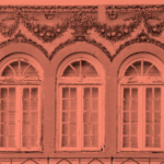 A red-filtered photo of three ornate windows