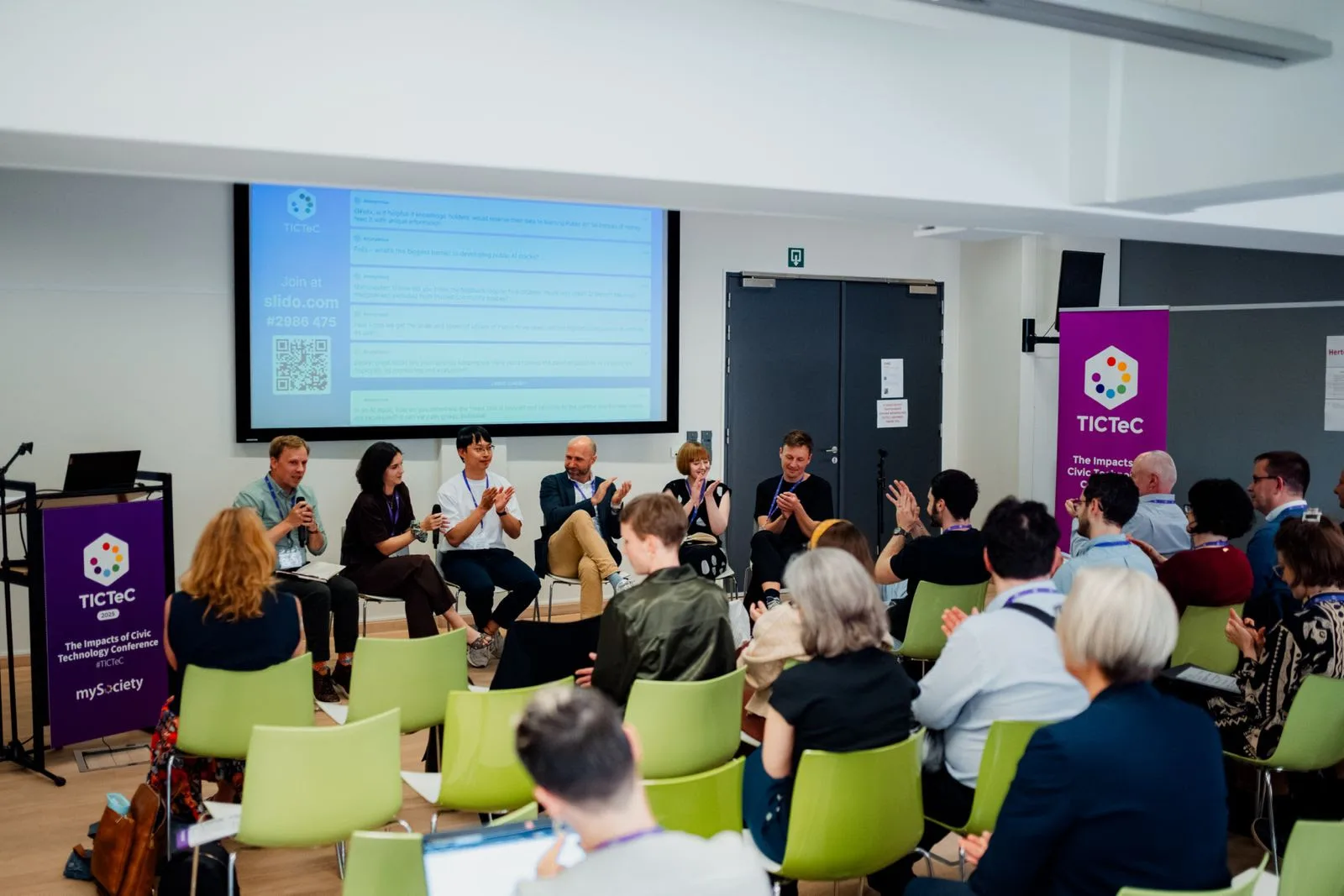 A panel addresses a room of people